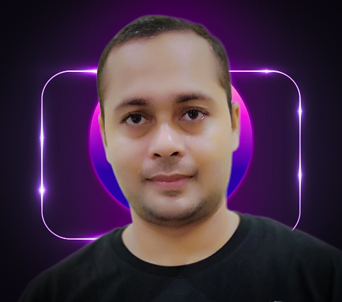 Pavan Mistry smiling in a red plaid shirt and tortoise shell glasses